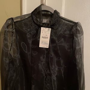 Black sheer long sleeve button down shirt with tie at the neck.